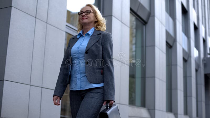 Heureuse patronne en costume de bureau de marche, bonne chef d'entreprise photos stock Heureuse patronne en costume de bureau de marche, bonne chef d'entreprise photos stock
