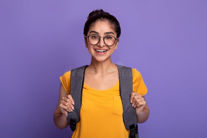 Heureuse étudiante indienne portant sac à dos et lunettes photo stock