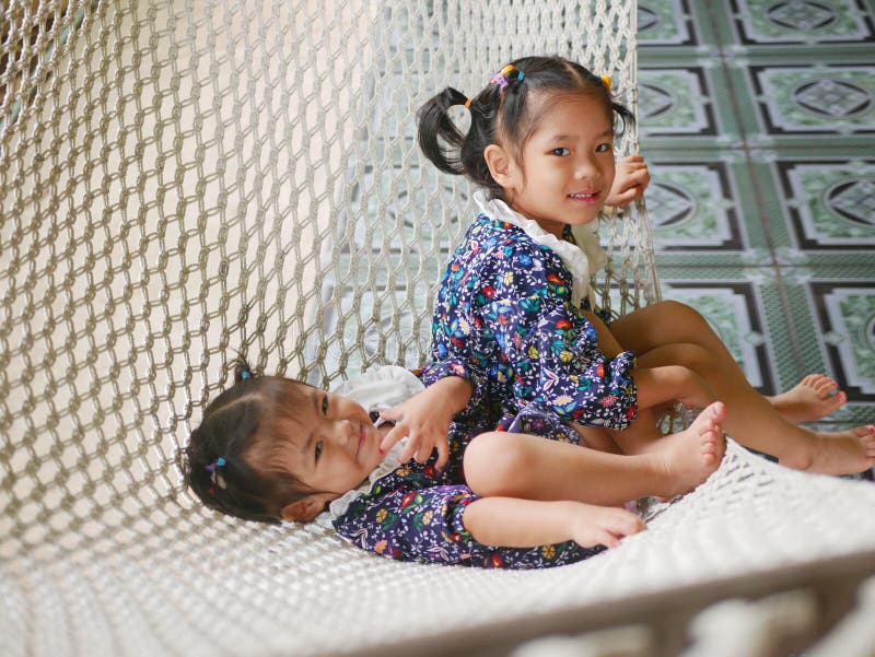 Heureuses petites filles asiatiques, soeurs, aiment être ensemble dans une relation hamac-frère image stock