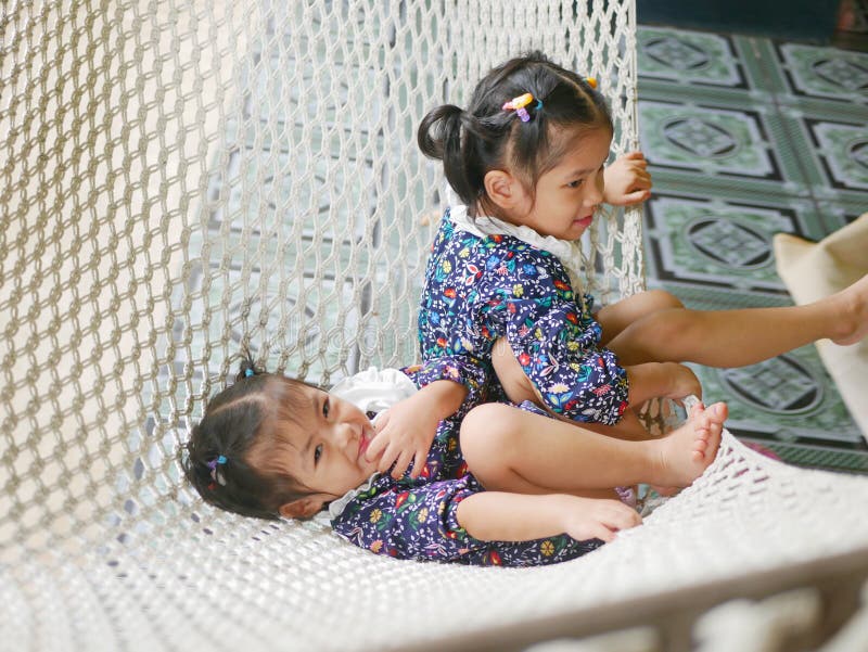 Heureuses petites filles asiatiques, soeurs, aiment être ensemble dans une relation hamac-frère photos libres de droits
