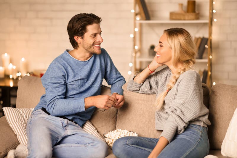 Heureux couple du millénaire parlant dans une chambre confortable photo stock