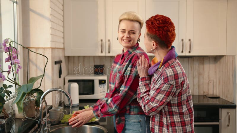 Heureux couple lave vaisselle ensemble dans une cuisine lumineuse remplie d'amour et de joie clips vidéos