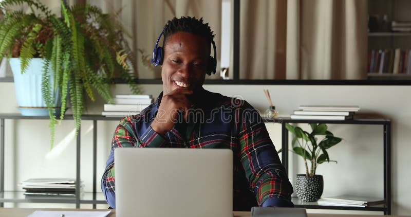 Heureux employé de l'ethnie africaine en utilisant l'application d'appel vidéo. banque de vidéos