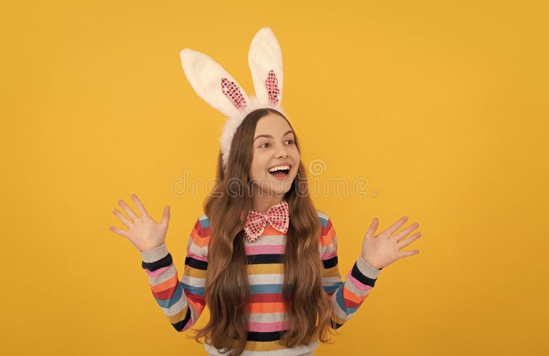 Heureux enfant de pâques dans les oreilles de lapin et noeud d'arc sur fond jaune image libre de droits