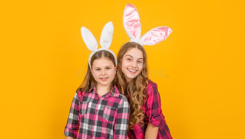 Heureux enfants de pâques dans des oreilles de lapin sur fond jaune photographie stock
