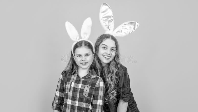 Heureux enfants de pâques dans des oreilles de lapin sur fond jaune.