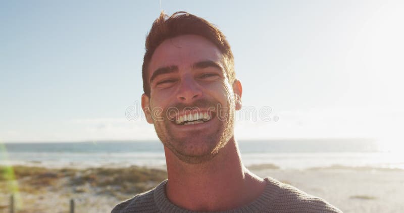 Heureux homme caucasien debout et souriant au bord de la mer clips vidéos