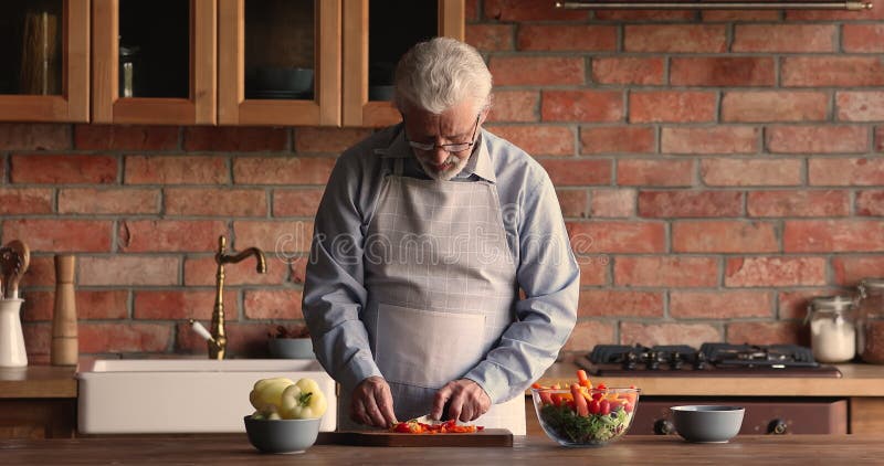 Heureux homme d'âge mûr impliqué dans la cuisine seul. banque de vidéos