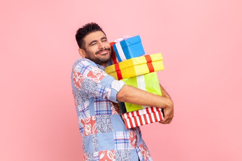 Heureux homme satisfait avec barbe en bleu casual style chemise embrasser la pile de boîtes présentes garder les yeux fermés profi photographie stock libre de droits