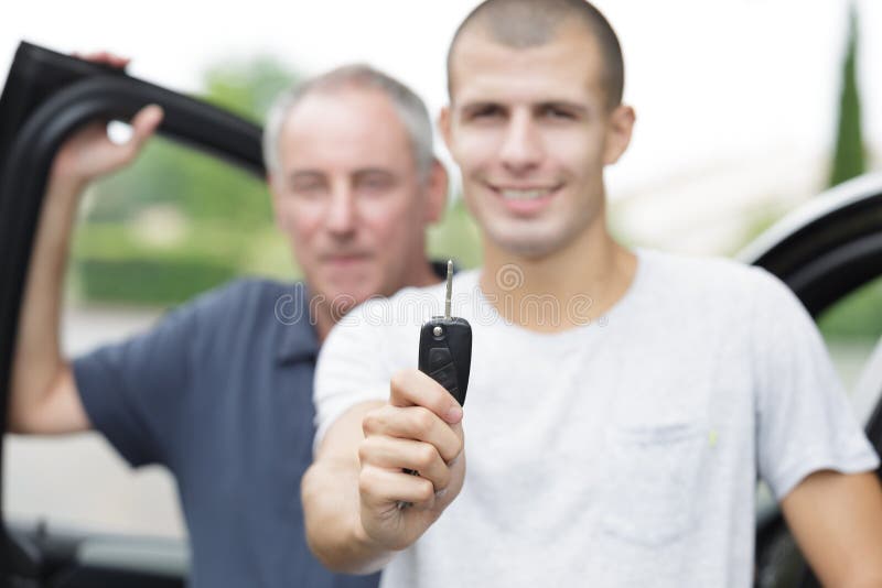 Heureux jeune acheteur tenant les clés près de voiture photos stock