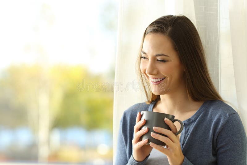 Heureux locataire buvant du café à côté d'une fenêtre image stock