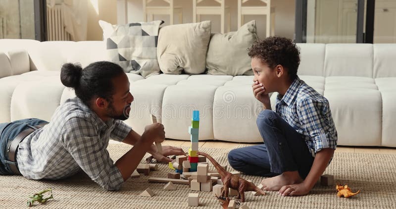 Heureux petit enfant afro-américain jouant avec père à la maison.