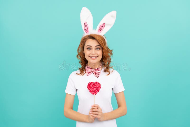 Heureux pâques femme porter des oreilles de lapin tenir coeur lollipop images stock