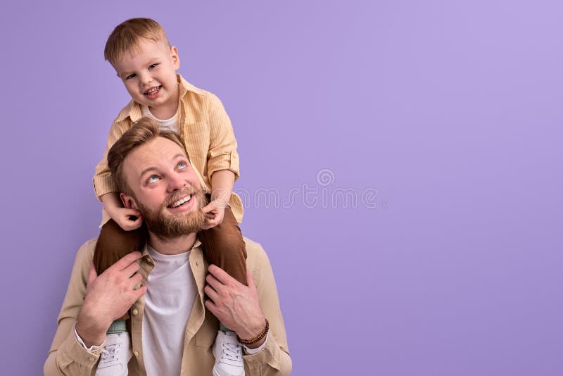 Heureux père et petit fils posant à la caméra souriant