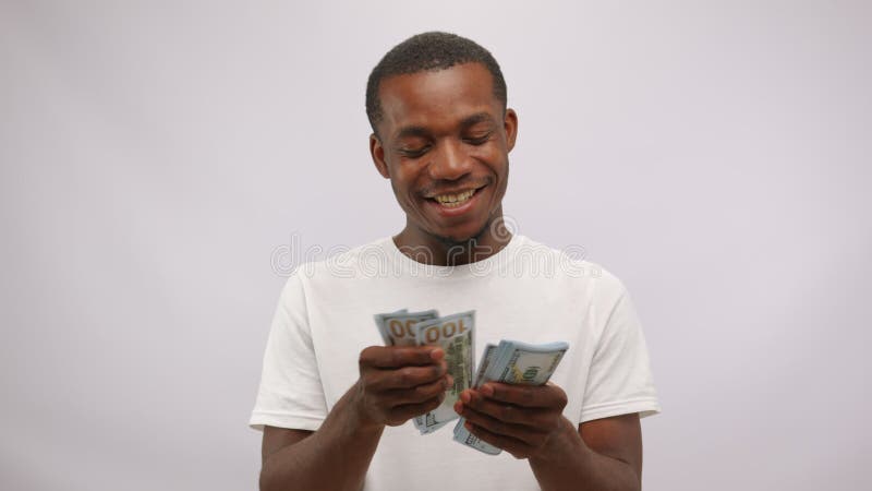 Heureux souriant bonifié afro-américain homme comptant des dollars sur fond blanc. clips vidéos