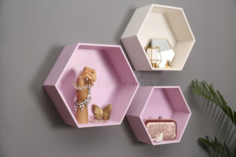 Hexagon Shaped Shelves with Different Stuff on Wall. Interior Design