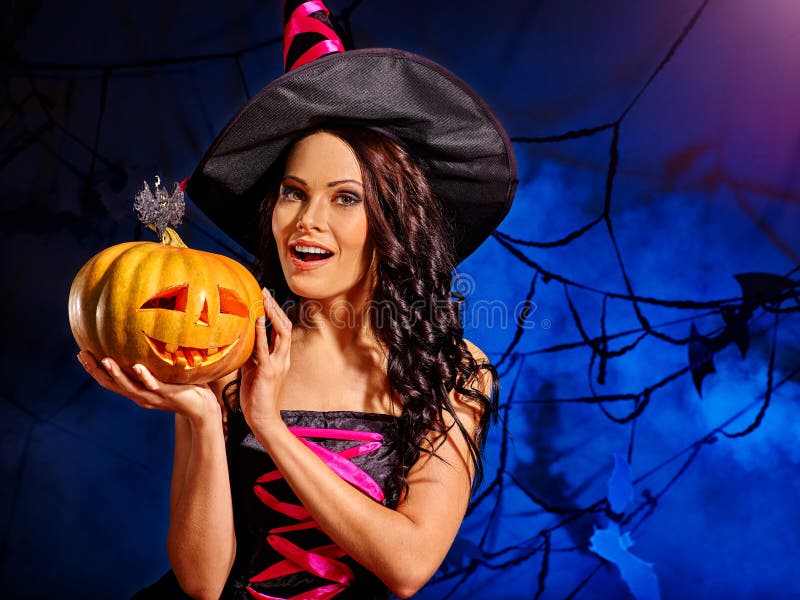 Hexe hält großen orange Halloween-Kürbis lizenzfreie stockfotografie Hexe hält großen orange Halloween-Kürbis lizenzfreie stockfotografie