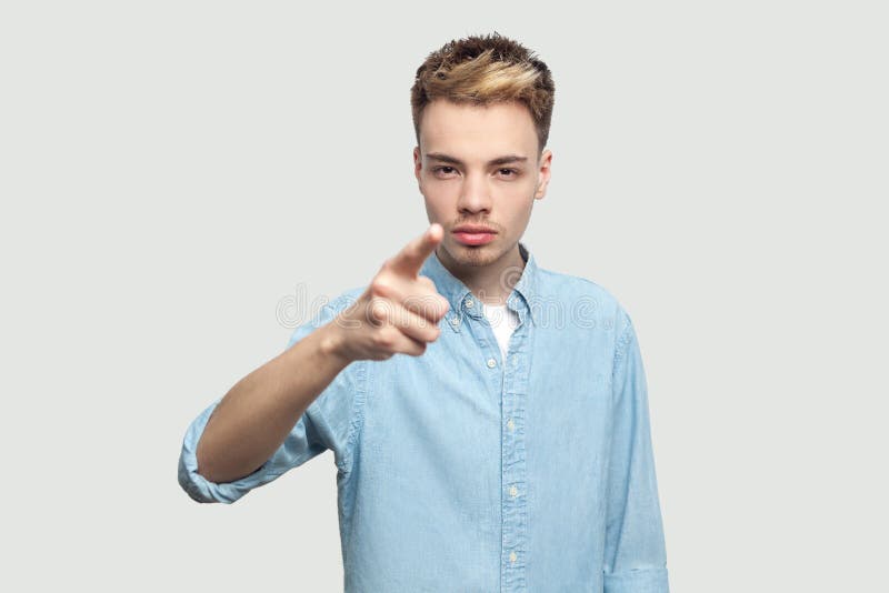 Hey you. Portrait of serious bossy handsome young man in light blue shirt standing, accusing and looking at camera with serious