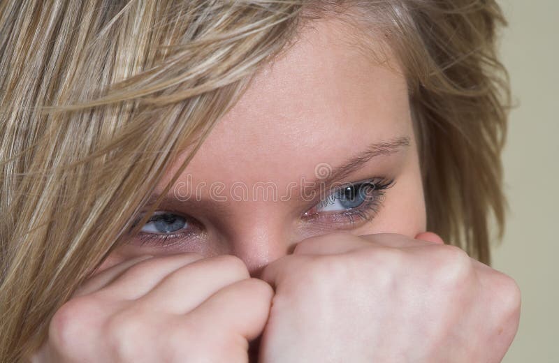Attractive young blonde hiding her face behind her hands. Lovely european female stock images, royalty-free photos and pictures