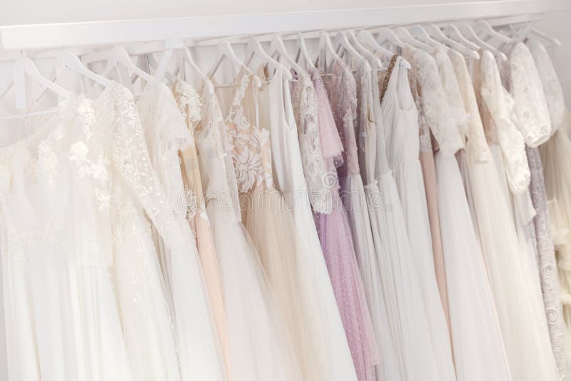 Beautiful wedding dresses with various designs hanging on the stand. Beautiful wedding dresses with various designs hanging on the stand