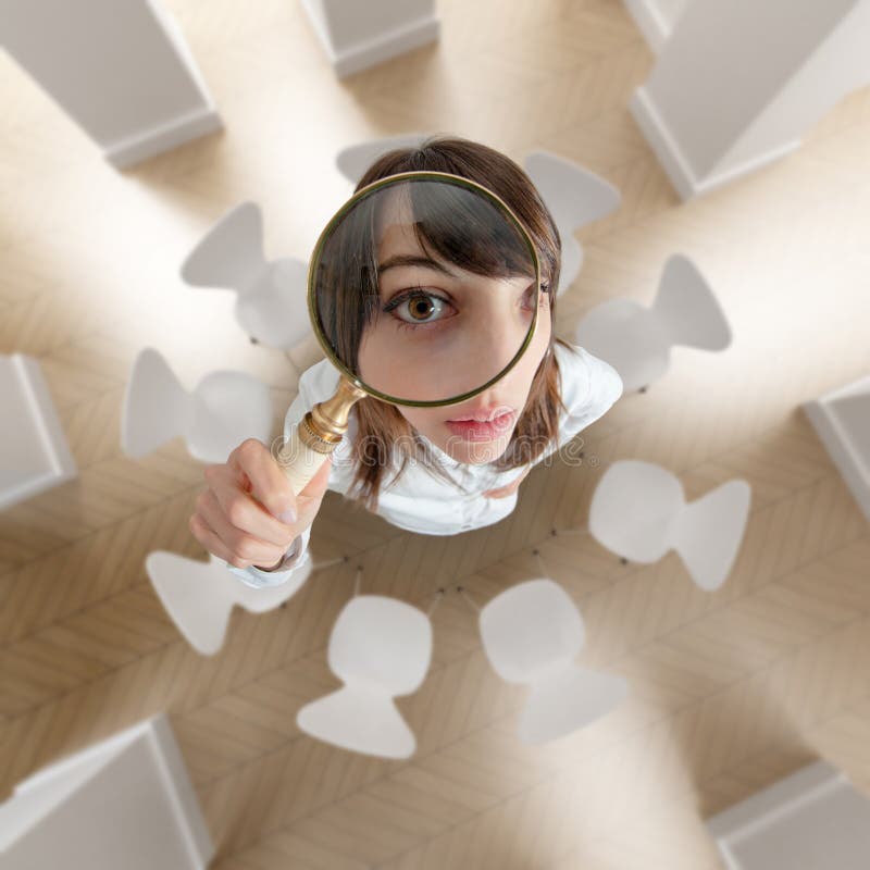 Aerial view of a young woman looking above through a magnifying glass. Aerial view of a young woman looking above through a magnifying glass