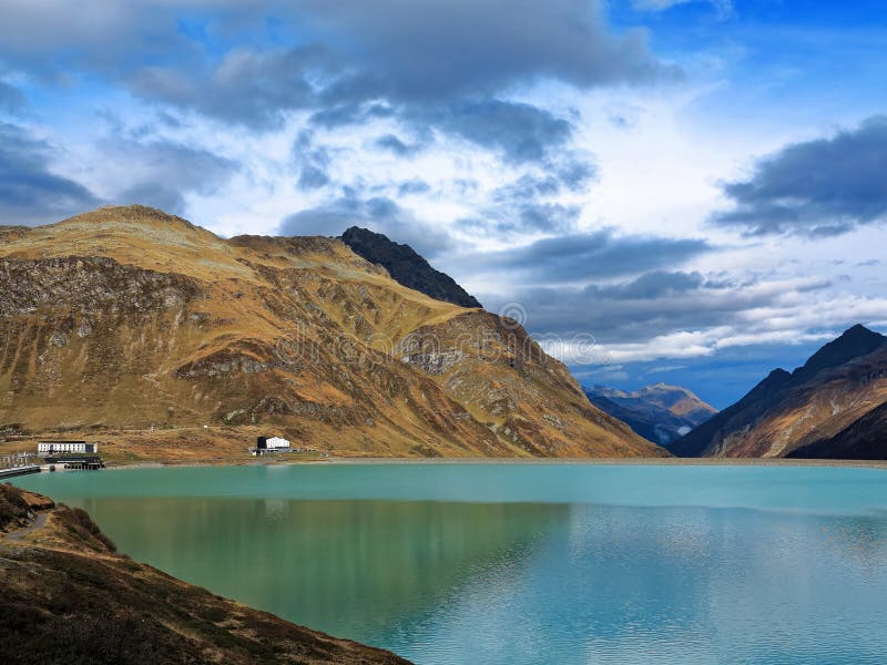 High alpine mountain lake with lakeside inn, autumnal colors
