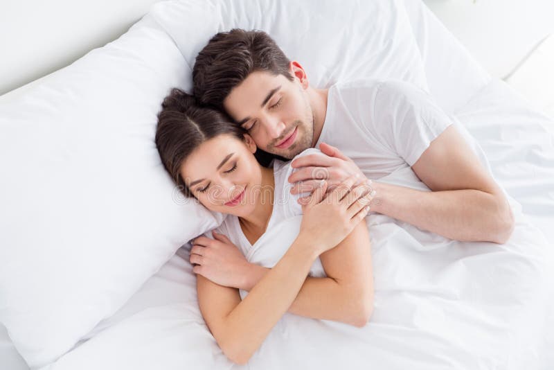 High angle above view photo charming cute lady husband guy couple lying comfortable sheets bed white blanket hugging stock images