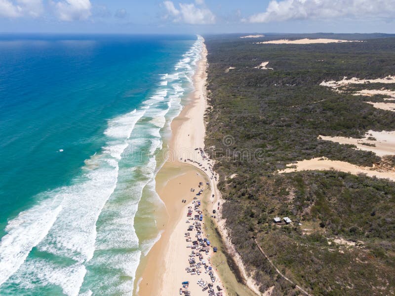 High angle aerial bird`s eye drone view of four-wheel drive cars parked at Eli Creek, a river mouth with crystal clear water