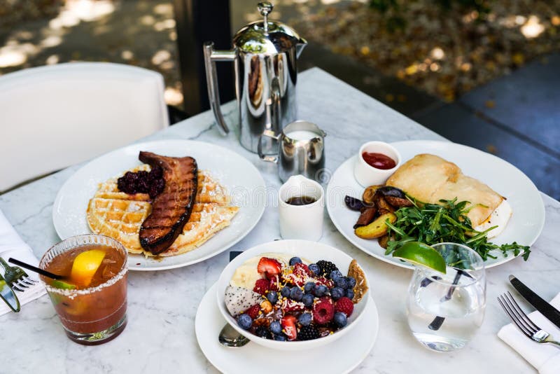 High angle shot of a lunch table with a plate filled with berries in the front stock photos
