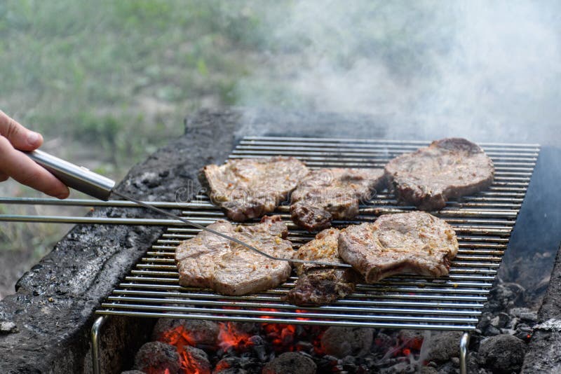 High Angle Shot of Steaks Cooking on a Flaming Grill Stock Photo