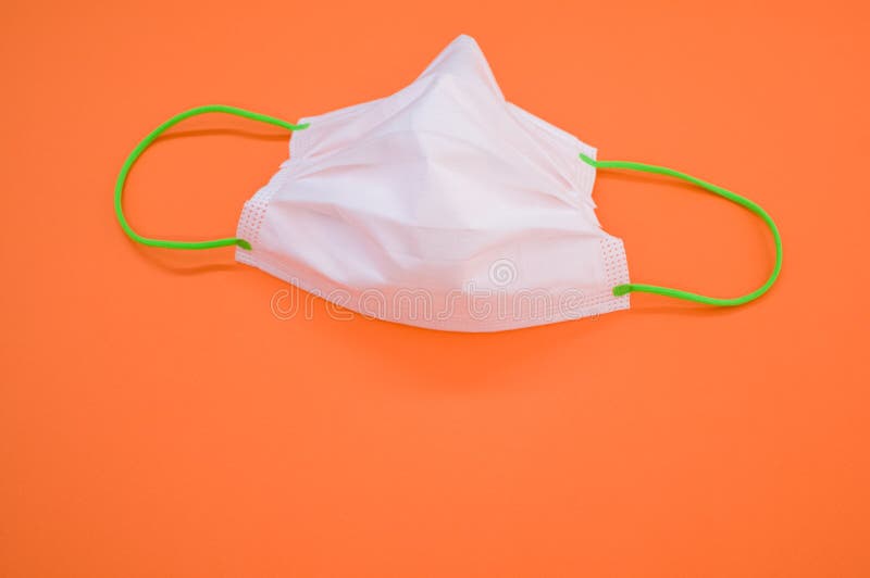 High Angle Shot of a Surgical Mask on an Orange Surface Stock Photo