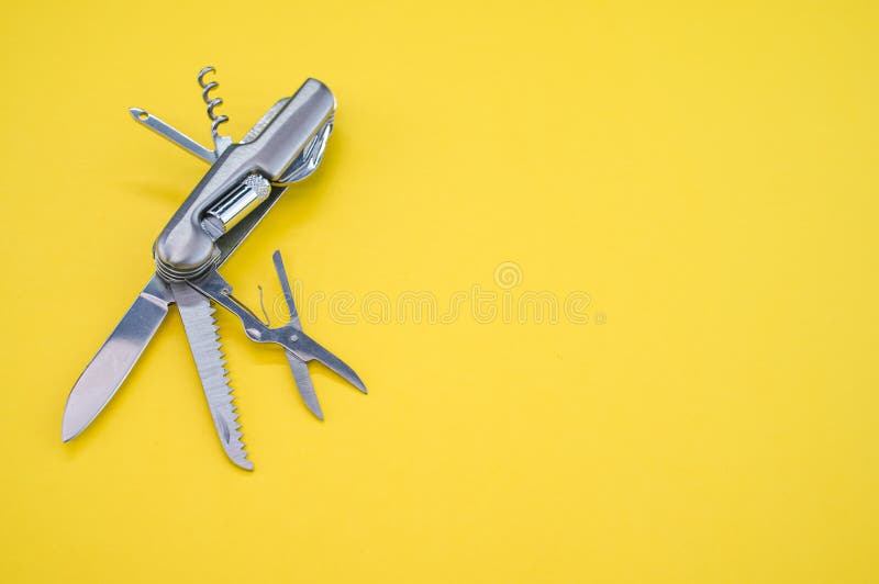 High Angle Shot of a Swiss Army Knife on a Yellow Surface Stock Photo
