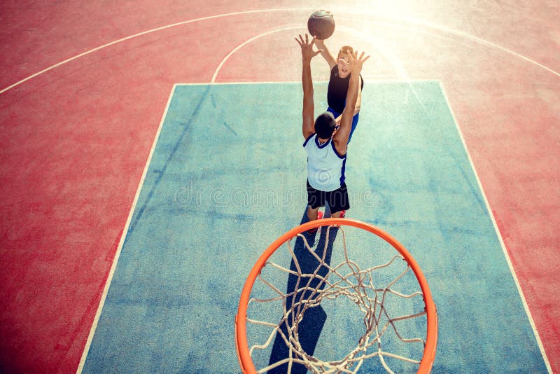 Slam Dunk. Side View Of Young Basketball Player Making Slam Dunk Stock
