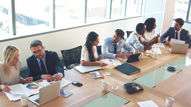 High Angle View Of Business Team Around Table In Modern Office Collaborating Together stock images