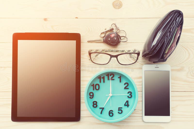 High angle view of businessman desk with cell tablet,smartphone, glasses and clock.