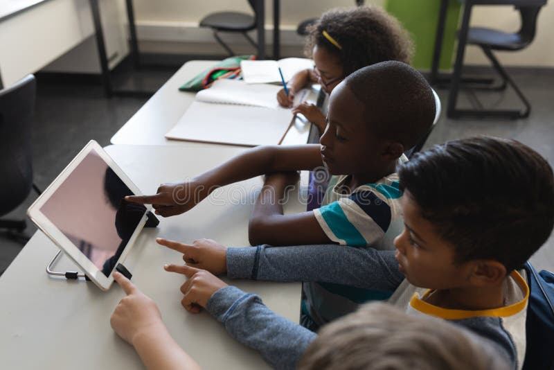 Kid in Classroom with Tablet Showing Gear Graphics Against Orange