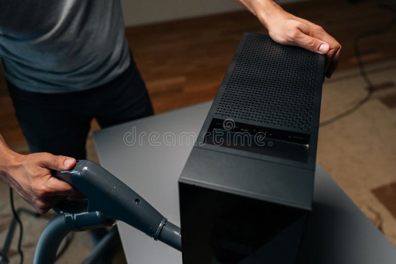 High-angle view of technician male using vacuum cleaner to remove dust and debris from ventilation holes of computer royalty free stock photography