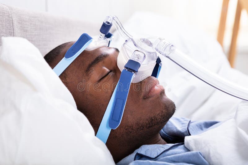 Man Wearing CPAP Mask Sleeping On Bed