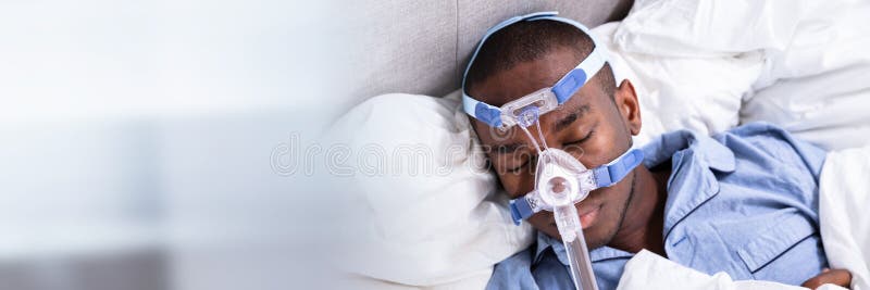 Man Wearing CPAP Mask Sleeping On Bed