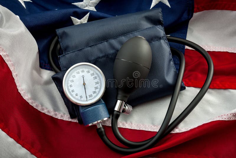 High blood pressure epidemic crisis in USA and american heart disease prevention concept with a sphygmomanometer generally used by a doctor to measure the blood pressure of a patient, on the US flag