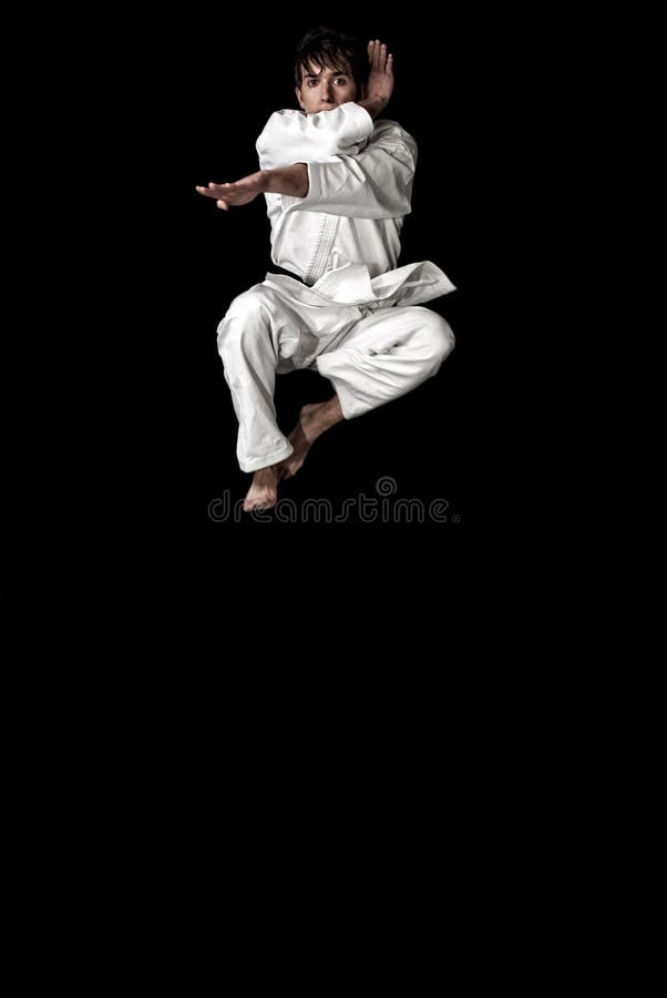 High Contrast karate young male fighter jump stock photography