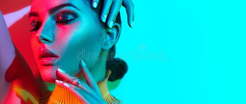 High Fashion model woman in colorful bright lights, portrait of beautiful sexy girl with trendy make-up and manicure