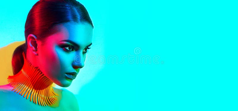 High Fashion model woman in colorful bright lights posing, portrait of beautiful sexy girl with trendy make-up. Art design