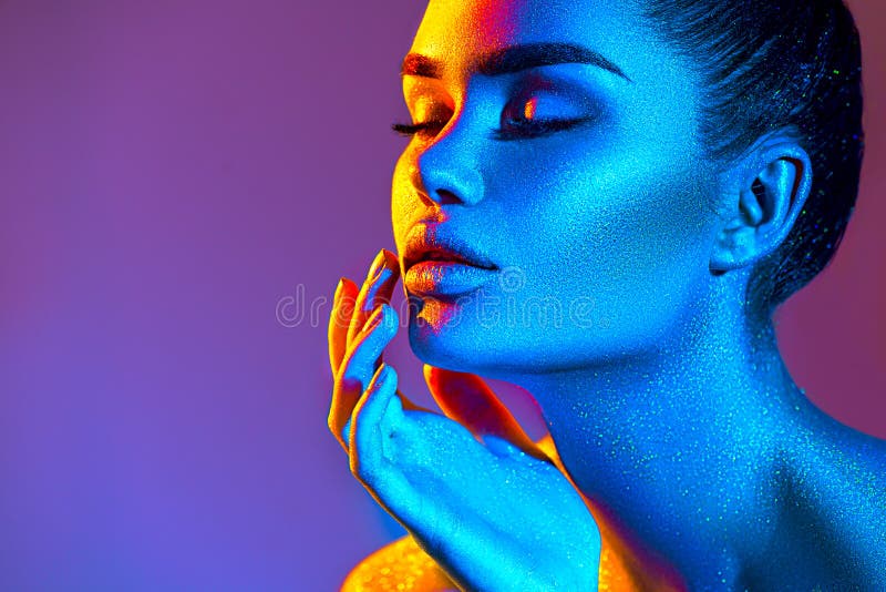 High Fashion model woman in colorful bright sparkles and neon lights. Beauty face, portrait of beautiful sexy girl, trendy makeup