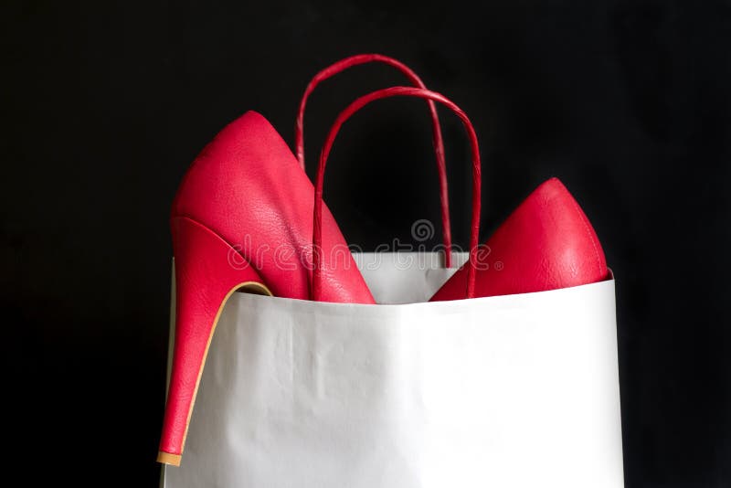 High heels red shoes in shopping bag