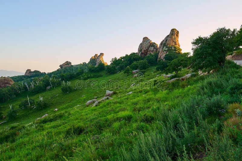 The high mountain meadow and huge rock sunset