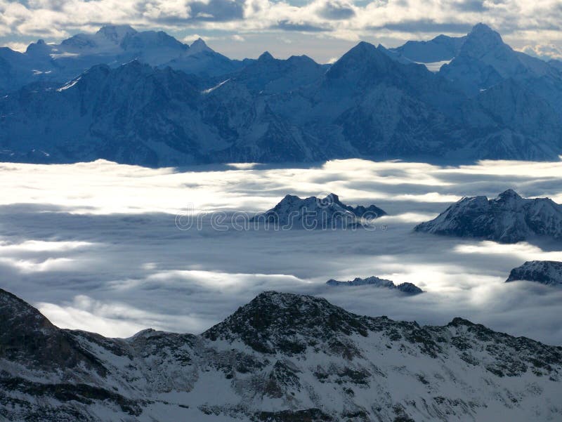 High mountains between cloud layers