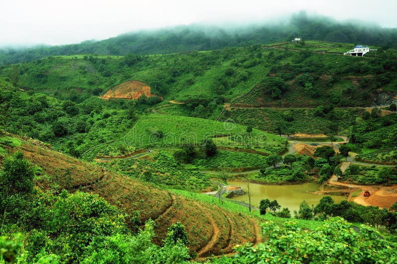 The high mountains tropical forest with clouds passing in India. royalty free stock image