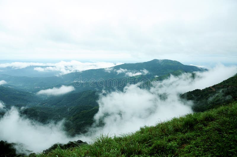 The high mountains tropical forest with clouds passing in India. stock photo