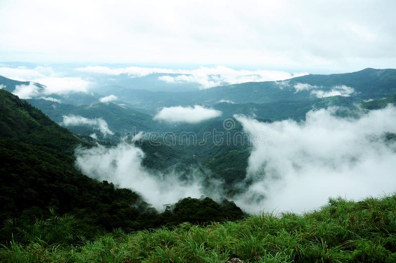 The high mountains tropical forest with clouds passing in India. royalty free stock images